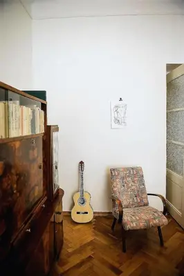 a living room with a guitar and a chair and a guitar at Stylish and unique 2 bedroom flat with balcony in Letna in Prague