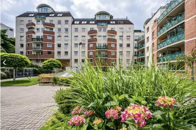 a garden with flowers in front of a building at Stylish 3-Room Flat City Views in Prague