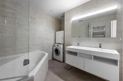 a bathroom with a tub and a sink and a washing machine at Stylish 3-Room Flat City Views in Prague