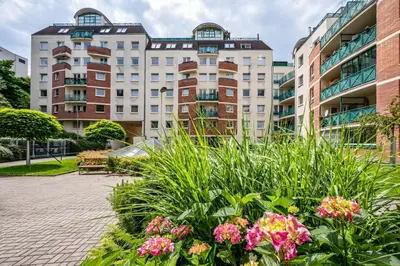 a garden with flowers in front of a building at Stylish 3-Room Flat City Views in Prague