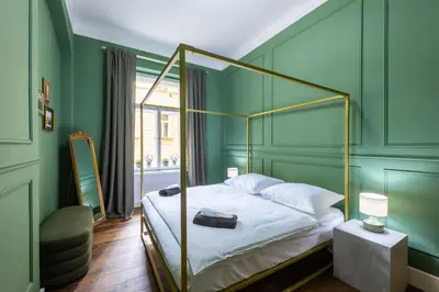 a bedroom with a bed with a green wall at Apartment Manes in Prague