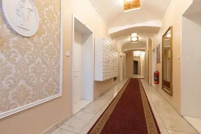 a hallway with a tile floor and a clock on the wall at Welcometothejungleapartment in Prague