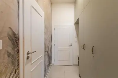 a hallway with a white door and a white floor at Welcometothejungleapartment in Prague