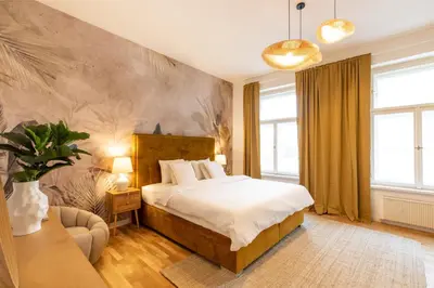 a bedroom with a large bed and a couch at Welcometothejungleapartment in Prague
