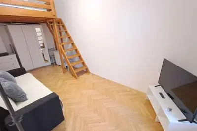 a living room with a television and a ladder at Cozy studio in Prague favorite neighborhood in Prague