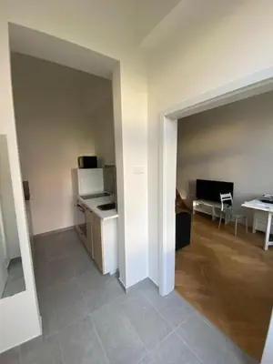 an empty room with a kitchen and a living room at Cozy studio in Prague favorite neighborhood in Prague