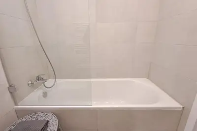 a white bath tub with a shower in a bathroom at Cozy studio in Prague favorite neighborhood in Prague