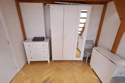 a bedroom with a white cabinet and a dresser at Cozy studio in Prague favorite neighborhood in Prague