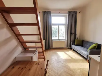 a living room with a staircase and a couch at Modern studio with excellent transport links in Prague