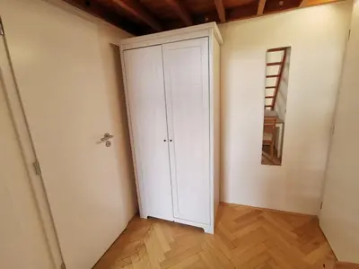 a white cabinet in a room with a ladder at Modern studio with excellent transport links in Prague