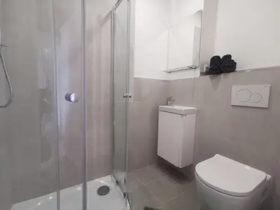 a bathroom with a toilet and a glass shower at Modern studio with excellent transport links in Prague