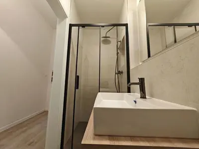 a white bathroom with a sink and a shower at Quiet Studio in Hip Zizkov in Prague