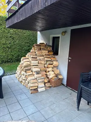 a pile of logs on the side of a house at Chata Roda s vnitřní saunou in Rabyně