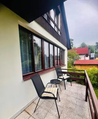 three chairs sitting on a balcony of a building at Chata Roda s vnitřní saunou in Rabyně