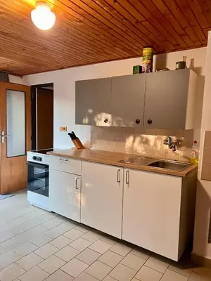 a kitchen with white cabinets and a sink at Chata Roda s vnitřní saunou in Rabyně