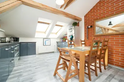 a kitchen with a wooden table and a brick wall at Bright and airy apartment in unique suburb in Prague
