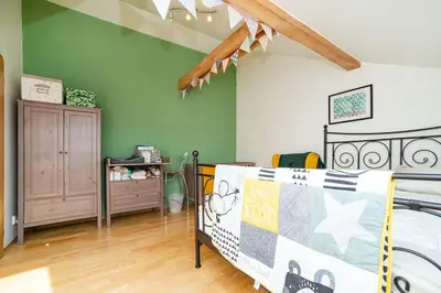 a bedroom with green walls and a bed and a dresser at Bright and airy apartment in unique suburb in Prague