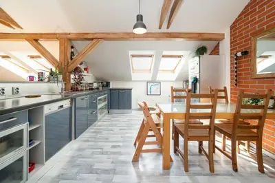 a kitchen with a table and chairs and a brick wall at Bright and airy apartment in unique suburb in Prague