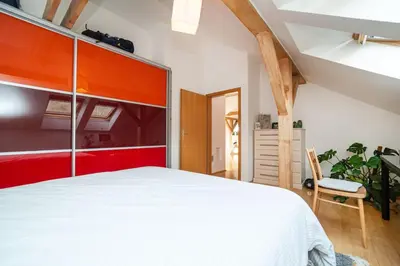 a bedroom with a large white bed and a chair at Bright and airy apartment in unique suburb in Prague
