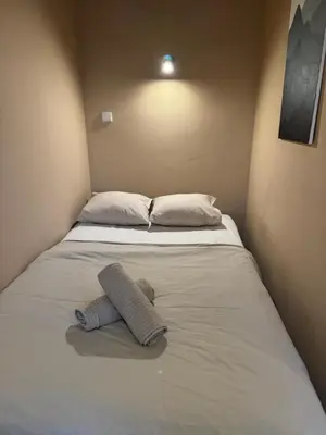 a bed with a teddy bear laying on it at Small studio in hipster neighborhood in Prague
