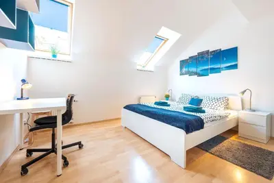 a white bedroom with a bed and a desk and a desk at Duplex City-Centre Apartment with a Sunny Terrace in Prague