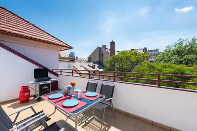 a patio with a table and chairs on a balcony at Duplex City-Centre Apartment with a Sunny Terrace in Prague