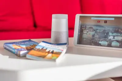 a table with a laptop and a book and a bottle at Duplex City-Centre Apartment with a Sunny Terrace in Prague