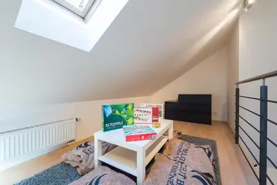a bedroom with a bed and a table with books on it at Duplex City-Centre Apartment with a Sunny Terrace in Prague