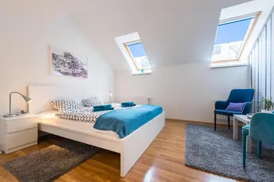 a bedroom with a bed and a desk and a chair at Large Duplex Apartment with a Sunny Terrace in Prague