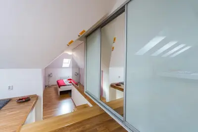 a room with a staircase and a living room at Large Duplex Apartment with a Sunny Terrace in Prague
