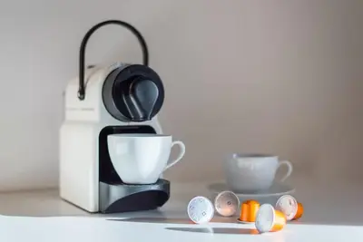 a black and white coffee maker next to two cups at Large Duplex Apartment with a Sunny Terrace in Prague