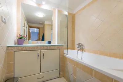 a bathroom with a tub and a sink and a mirror at Large Duplex Apartment with a Sunny Terrace in Prague