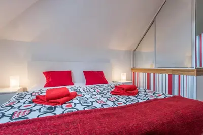 a bedroom with a large bed with red pillows at Large Duplex Apartment with a Sunny Terrace in Prague