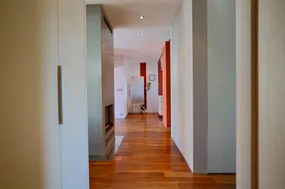 a hallway of an apartment with white walls and wooden floors at Luxury Prague Penthouse with Heated Floors, Castle Views & Rooftop Terrace in Prague