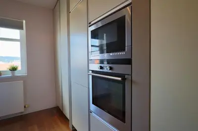 a kitchen with a stainless steel oven with a microwave at Luxury Prague Penthouse with Heated Floors, Castle Views & Rooftop Terrace in Prague