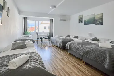 a room with four beds and a dining room with a table at MIRA apartments in Prague