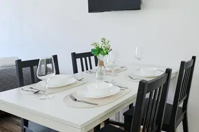 a dining room table with white plates and wine glasses at MIRA apartments in Prague