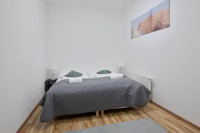 a bedroom with a bed in a white wall at MIRA apartments in Prague