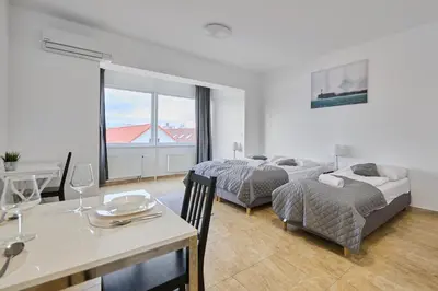 a living room with two beds and a dining table at MIRA apartments in Prague