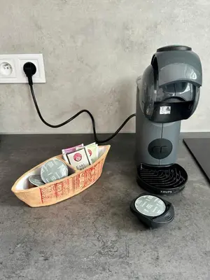 a coffee maker with a bowl of money next to a coffee pot at Byt u letiště v Praze in Tuchoměřice