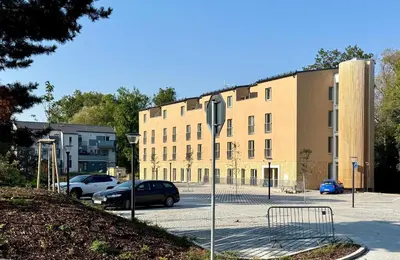 a building with cars parked in a parking lot at Byt u letiště v Praze in Tuchoměřice