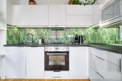 a white kitchen with white cabinets and a sink at Sunset & Bloom Attic - Near parks & cafés in Prague