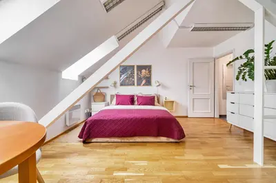a bedroom with a bed with a purple bedspread at Sunset & Bloom Attic - Near parks & cafés in Prague