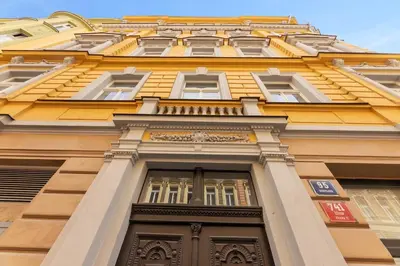 a tall yellow building with a door at Sunset & Bloom Attic - Near parks & cafés in Prague