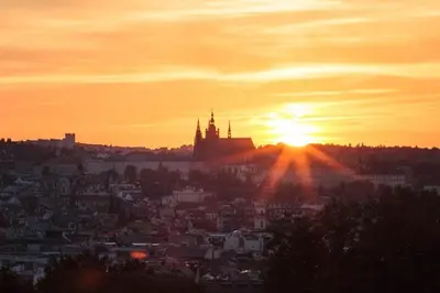 a view of a city with the sun setting at Sunset & Bloom Attic - Near parks & cafés in Prague