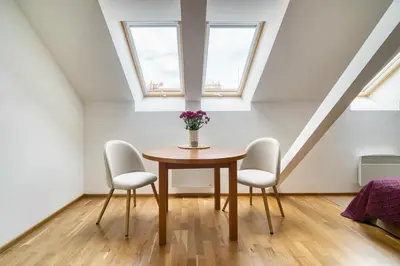 a dining room with a table and two chairs at Sunset & Bloom Attic - Near parks & cafés in Prague