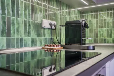 a green tiled kitchen with a glass counter top at Sunset & Bloom Attic - Near parks & cafés in Prague