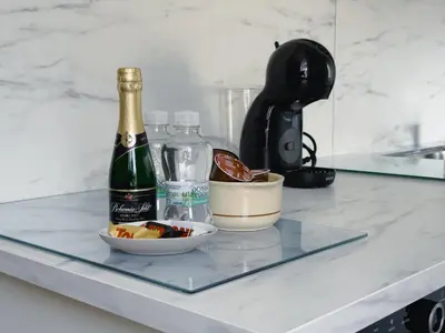 a bottle of champagne and a bowl of fruit on a counter at Cheerful apartment in the heart of Prague in Prague