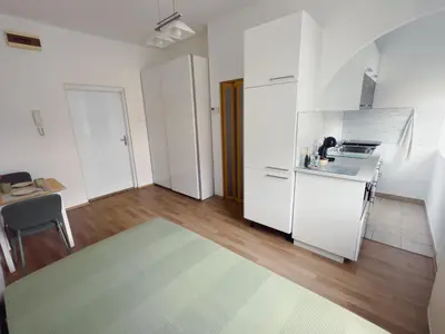 a kitchen with white cabinets and a table in a room at Cheerful apartment in the heart of Prague in Prague