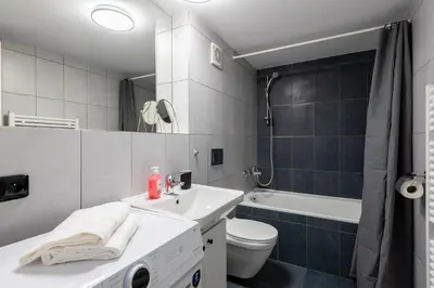 a bathroom with a sink and a toilet and a tub at Cozy apartments near Křižikova metro in Prague